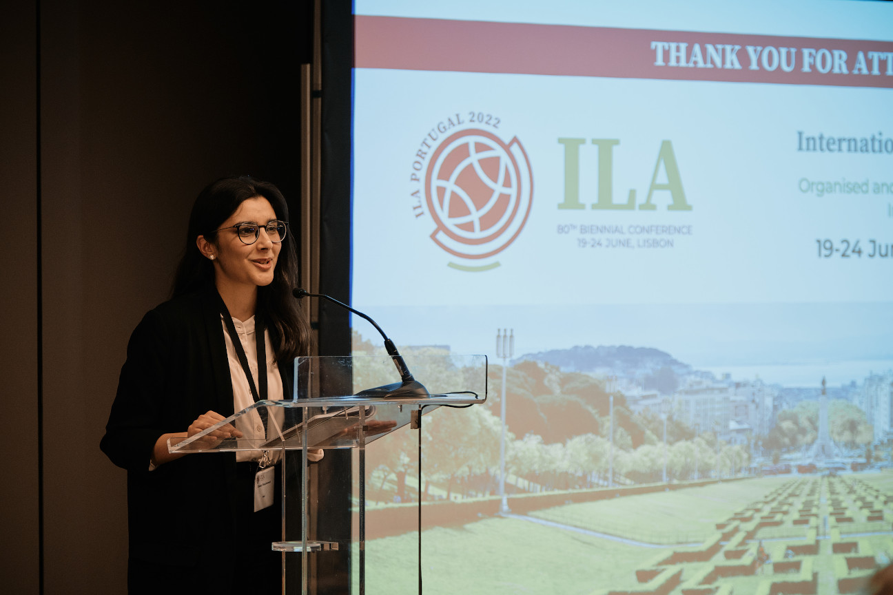 Young woman standing at lecturn presenting speech at ILA conference 2022